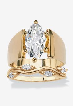 a yellow gold ring with an oval cut diamond in the center and two smaller diamonds on each band