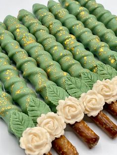 there are many green and white desserts with flowers on them that look like they were made out of candy