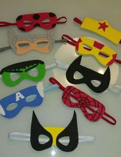 a bunch of masks are sitting on a table together, all in different colors and shapes