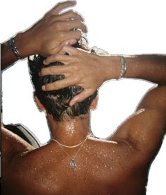 the back of a man's head with his hands on his hair and wearing bracelets