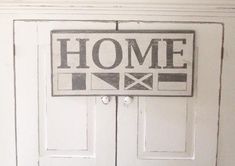 a white door with a sign that says home on it and a flag painted on the front