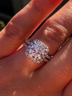 a woman's hand with a ring on it and a diamond in the middle