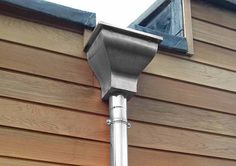 a metal pole on the side of a house with a blue skylight above it