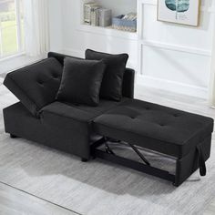 a black couch sitting on top of a white rug