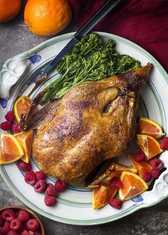 a whole chicken on a plate with fruit and vegetables