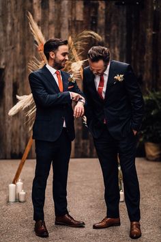 groom in a navy suit and orange wedding tie Black Suit Rust Tie Wedding, Groom Burnt Orange, Black Suit Brown Shoes Wedding Groomsmen, Navy Blue Tuxedo Wedding With Orange, Black Suit With Rust Tie, Navy Blue Suit Rust Tie, Navy Blue Suit With Rust Tie, Rust Wedding Groom, Guys Fall Wedding Outfit