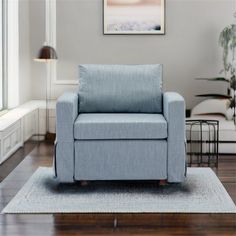 a blue chair sitting on top of a wooden floor next to a white wall and window