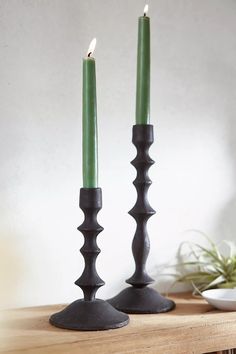 two candles sitting on top of a wooden table