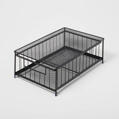 a black cage with two drawers and a wooden handle on the bottom, in front of a white background