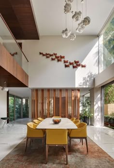 a dining room with yellow chairs and a white table