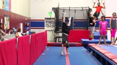 some kids are doing tricks on the trampoline in an indoor gymnastics gym while others watch