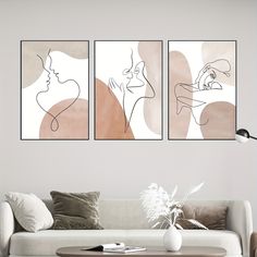 three abstract paintings hang on the wall above a couch in a living room with a coffee table