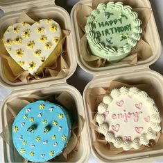 four decorated heart shaped birthday cakes in small trays