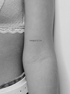 the back of a woman's left arm with an emptia tattoo on it