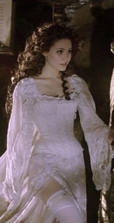 a woman in a white dress with long sleeves