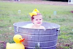 a baby in a tub with bubbles and a rubber duck