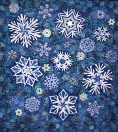 a blue quilt with white snowflakes on it