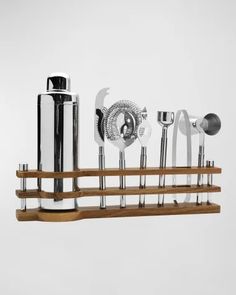 an assortment of kitchen utensils are arranged on a wooden rack with metal handles