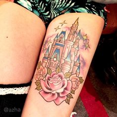 a woman's thigh with a tattoo of a castle and rose on her leg