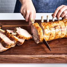 a person slicing meat on a cutting board