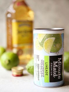 a can of lemonade next to some limes