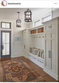 an entryway with built in cabinets and a large rug on the floor next to it