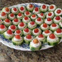 cucumber and tomato appetizers are arranged on a platter, ready to be served