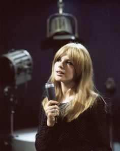 a woman holding a microphone in front of a camera