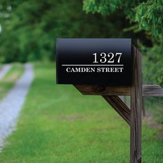 a mailbox sitting on the side of a road in front of a grassy field