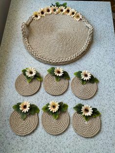 six straw coasters with flowers on them sitting on top of a white countertop