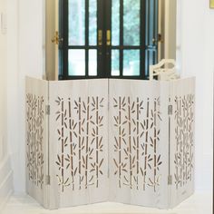 a room divider made out of wood with laser cut designs on the doors and windows