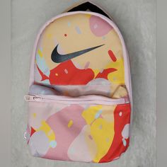 Insulated Lunch Bag. Wrap-Around Main Zip Compartment Dimensions: 10.75" H X 7" W X 4.5" D Material: 100% Polyester Spot Clean Multicolor Bags For Daycare And Back To School, Fun Red Bags For Back To School, Playful Yellow Bags For Back To School, Fun Yellow Backpack Bag, Red Nike Travel Bag, Nike Red Travel Bag, Fun Yellow Backpack, Nike Pink Backpack For School, Nike Pink Bag For Daily Use