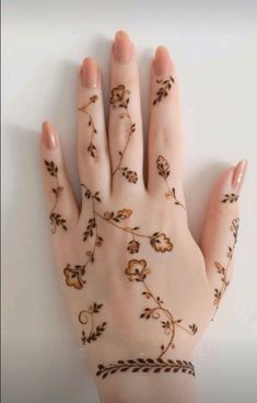 a woman's hand with hennap on it and flowers painted on the palm