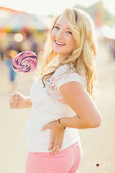 a woman holding a lollipop in her right hand