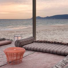 an orange table sitting on top of a beach next to the ocean