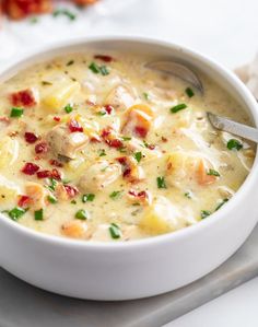 a white bowl filled with soup on top of a table next to a fork and napkin