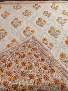 two quilted bedspreads with yellow flowers on them