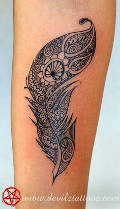 a black and white photo of a tattoo design on the leg, with a feather