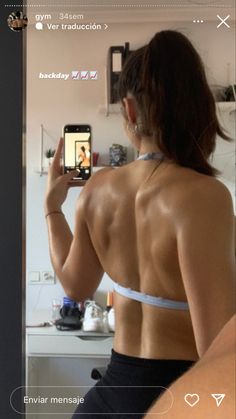 a woman taking a selfie with her cell phone in front of her back,