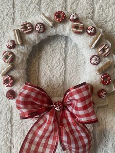 a red and white christmas wreath with donuts on the front, ribbon tied around it