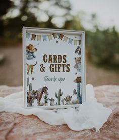 a card and gift box sitting on top of a rock with the words cards & gifts thank you