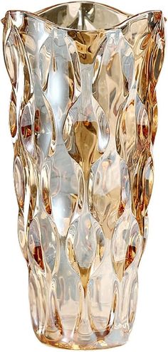 a glass vase that is sitting on a white surface with gold trimmings and an intricate design