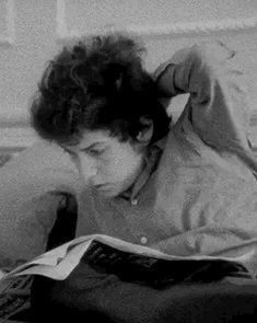 a woman laying on top of a bed reading a book