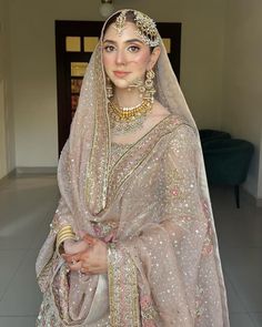 a woman in a bridal gown with jewelry on her head and veil over her face