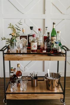 a bar cart filled with liquor bottles and glasses