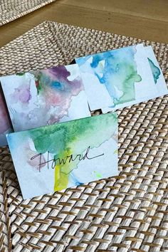 three watercolor cards sitting on top of a wicker table