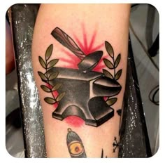 a tattoo with an image of a hammer and some plants on it's leg