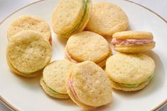 a white plate topped with cookies and sandwiches