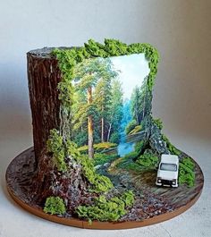 there is a cake that looks like a forest scene with a car on the road