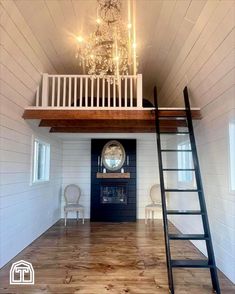 a living room with a ladder and a chandelier above the fireplace in it